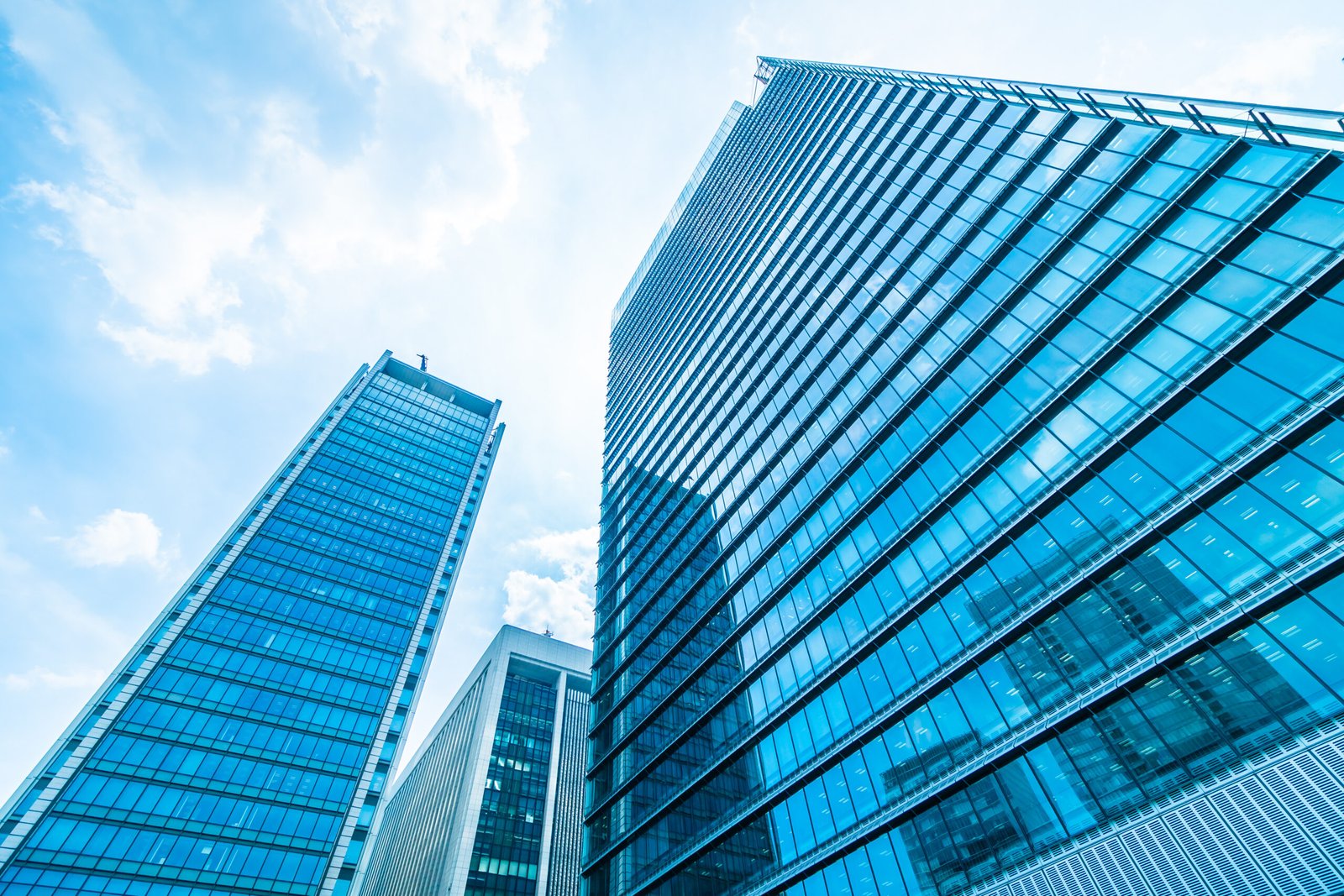 Two tall buildings covered in blue glass