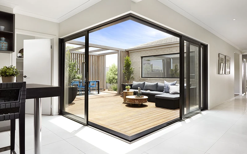 A corner window that slides open onto a wooden deck